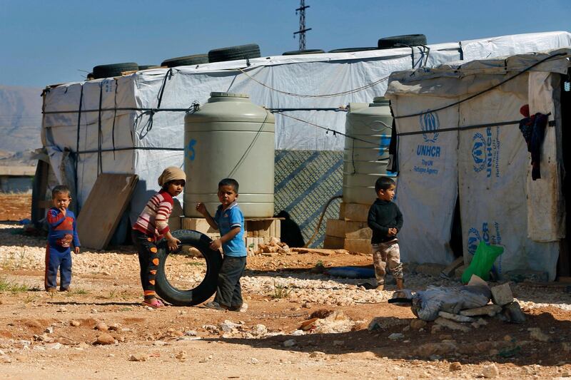 FILE - In this June 20, 2017 file photo, Syrian refugee children play outside their family tents at a Syrian refugee camp in the eastern city of Baalbek, Lebanon. The U.N. agency for Palestinian refugees said Wednesday, April 22, 20202, that a Palestinian woman from Syria living in a refugee camp in Lebanon has become the first refugee to test positive for the coronavirus. (AP Photo/Bilal Hussein, File)