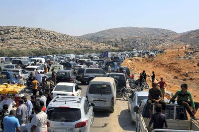 Cars and trucks line up to enter Turkey as hundreds of protesters gather during a demonstration at the Bab al-Hawa border crossing with Turkey, Syria, Friday, Aug. 30, 2019, demanding that Ankara either open the border or end attacks by the government. Opposition activists said Turkish borders guards fired tear gas at the protesters. (AP Photo)