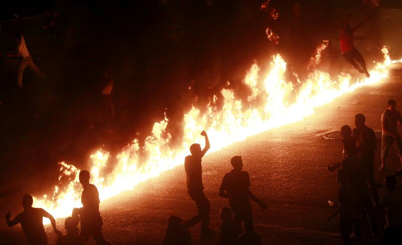 Protesters jump and run near a line of fire during a demonstration in Cairo October 9, 2011. Nineteen people were killed in Cairo on Sunday when Christians, some carrying crosses and pictures of Jesus, clashed with military police, medical and security sources said, in the latest sectarian flare-up in a country in political turmoil. REUTERS/Amr Abdallah Dalsh  (EGYPT) *** Local Caption ***  AMR14_EGYPT-COPTS-C_1009_11.JPG