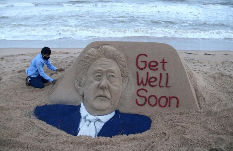 Indian sand artist Sudarsan Pattnaik touches up a sculpture for Mr Abe at the Puri Beach, near Bhubaneswar, India, August 29. EPA