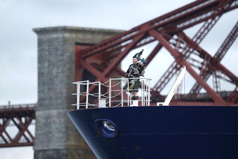 A traditional Scottish piper plays as the tanker carrying the first shipment of US shale gas passes under the Forth Bridge. Russell Cheyne / Reuters