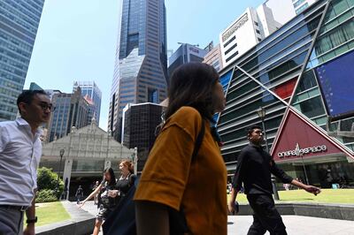 People walk out for their lunch break at the Raffles Place financial business district in Singapore on October 14, 2019. Singapore eased monetary policy for the first time in more than three years on October 14 as the US-China trade war bites, while the export-reliant economy narrowly avoided recession in the third quarter. / AFP / Roslan RAHMAN
