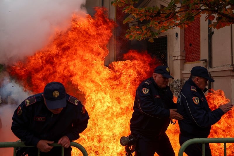 Police officers in Tirana, Albania, retreat from Molotov cocktails thrown by protesters outside the mayor's office, where a crowd gathered to accuse him of corruption. Reuters