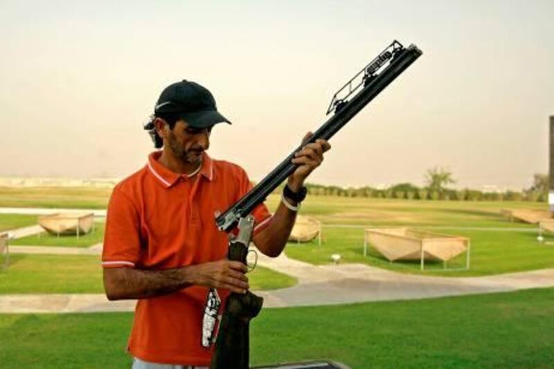 Emirati Olympic shooting gold medalist Sheikh Ahmed bin Hasher al-Maktoum, a member of Dubai's ruling family, fixes his Beretta competition shotgun at Nad al-Shiba in Dubai, July 27, 2008, during a training session just hours before leaving for China to defend his title in the double trap shooting event. AFP PHOTO/MARWAN NAAMANI *** Local Caption ***  959032-01-08.jpg