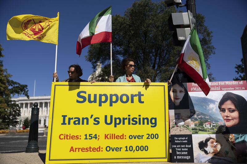 Protesters on Capitol Hill hold a sign condemning the crackdown by Tehran. AFP