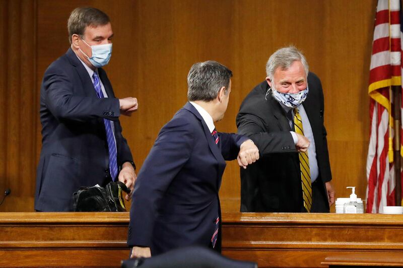 Representative John Ratcliffe, centre, arrives to a Senate Intelligence Committee nomination hearing on Capitol Hill in Washington,  and is greeted by committee Chairman Senator Richard Burr and Vice Chairman Senator Mark Warner., left.  AP Photo