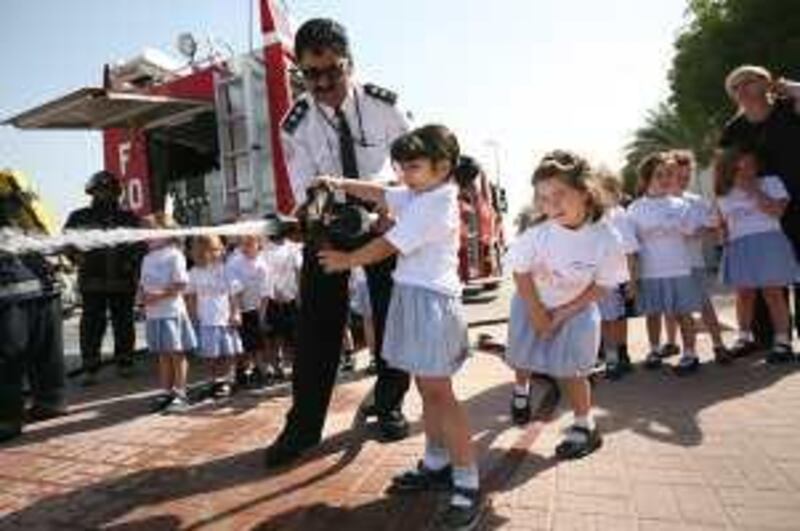 United Arab Emirates- Dubai - February 10, 2010:

NATIONAL: Jebel Ali Port Fire Department fire officer Sebastian Alemao (cq-al), center, shows student Michelle Khaled, 5, center, how to use the fire hose during a fire safety demonstration at the Jebel Ali Primary School school in Dubai on Wednesday, February 10, 2010. Amy Leang/The National