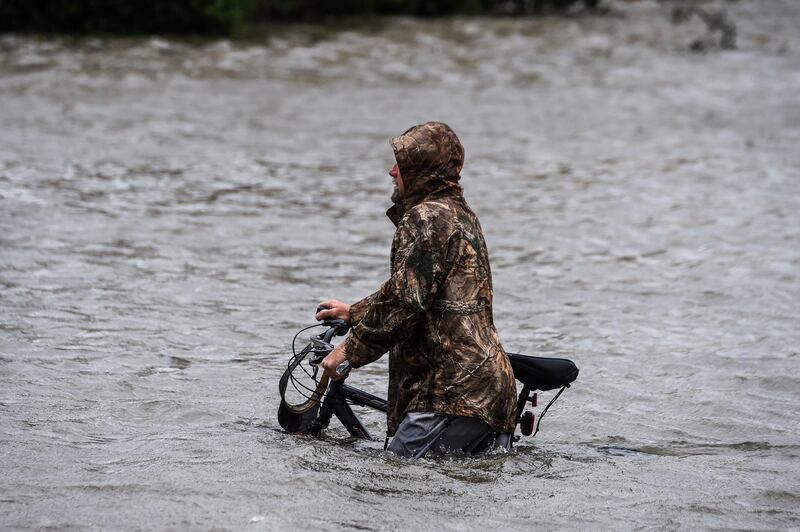 A man walks his bicycle through a street flooded by Hurricane Sally in Pensacola, Florida.  AFP