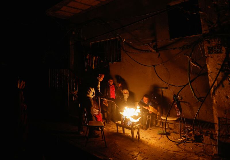 Palestinians sit next to a fire in Khan Younis in the southern Gaza Strip. Reuters