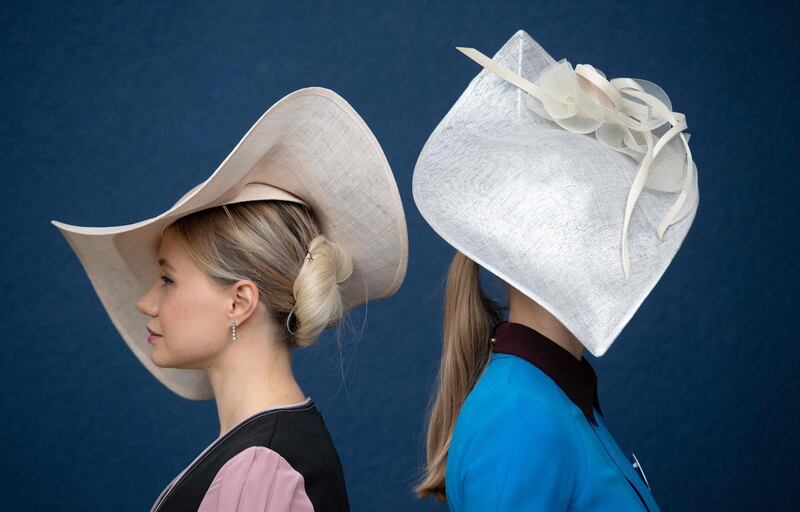 Racegoers strike a pose against a royal blue wall.  APF