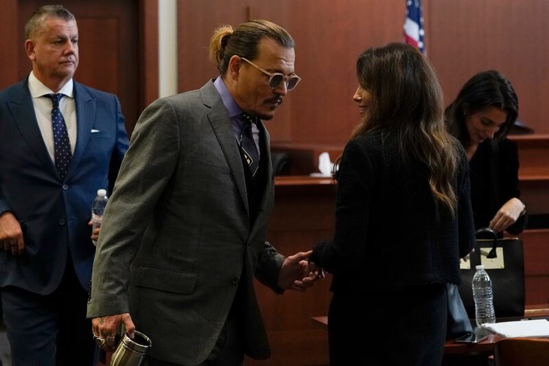 Depp greets his legal team as he arrives at Fairfax County Circuit Court, where he is suing his ex-wife for libel. EPA