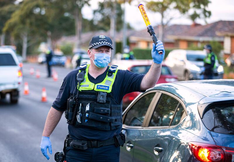 A police officer directs traffic at a roadblock in suburban Melbourne, Australia. Thousands of residents in dozens of suburbs of Melbourne are preparing to lock down for a month with the Victoria state premier warning a state-wide shutdown is possible if coronavirus cases continue to rise. AAP Image via AP