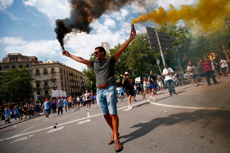 A protester wearing lights flares during a strike by taxi drivers in Barcelona.  AFP / Pau Barrena