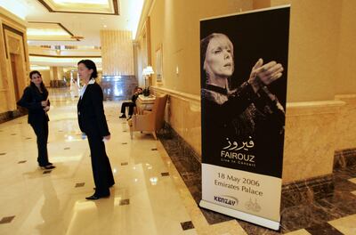 Guests walk past a poster announcing a live concert by Fairouz at Abu Dhabi's Emirates Palace. AFP