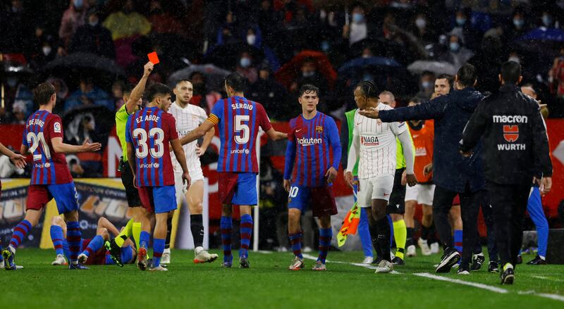 Sevilla's Jules Kounde is shown a red card by referee Carlos Del Cerro. Reuters