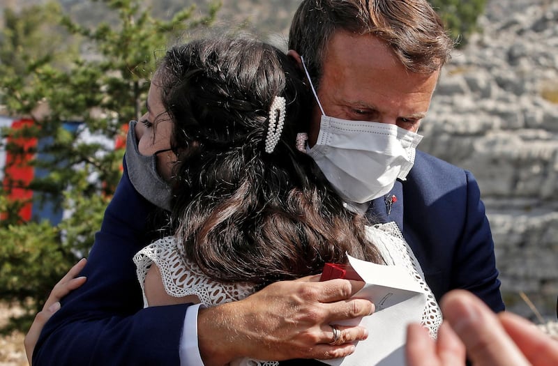 French President Emmanuel Macron hugs a blast victim, Tamara Tayah, while attending a ceremony to mark Lebanon's centenary in Jaj Cedars Reserve Forest, northeast of the capital Beirut. AFP