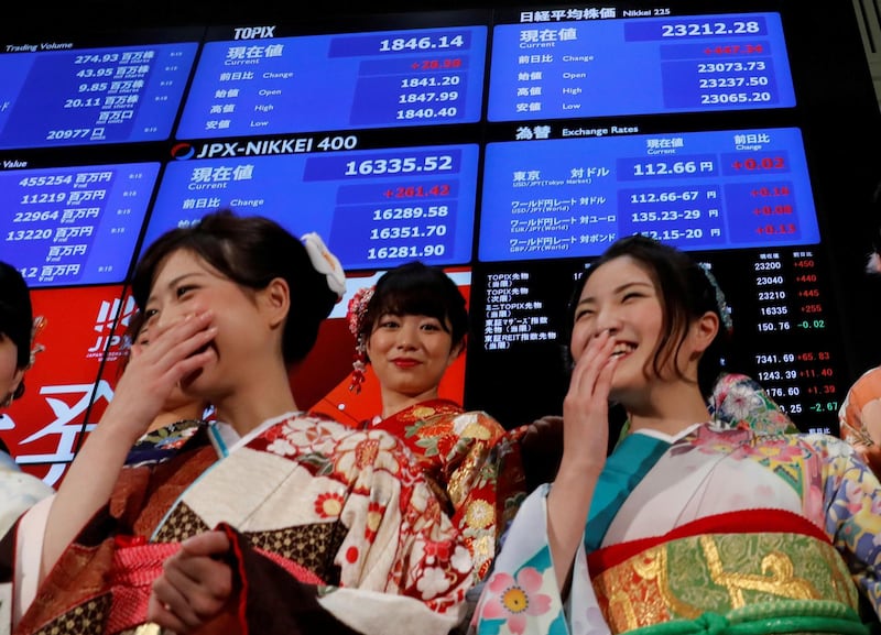 Women, dressed in ceremonial kimonos, smile in front of an electronic board displaying the Nikkei average (top in R) as they pose after the ceremony which kicks off the first day of trading in 2018 at the Tokyo Stock Exchange in Tokyo, Japan January 4, 2018. REUTERS/Kim Kyung-Hoon     TPX IMAGES OF THE DAY
