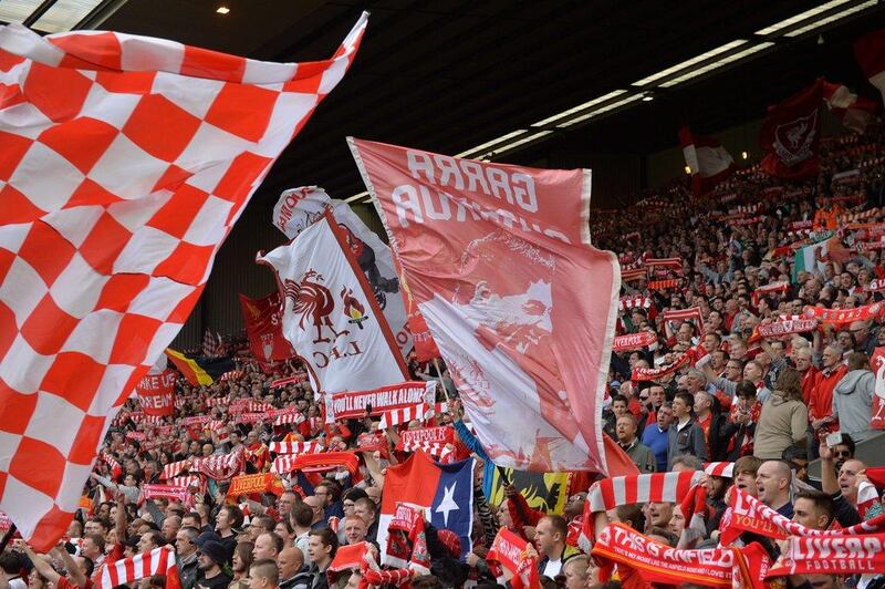 Liverpool fans wave flags and scarves during a Premier League match against Tottenham Hotspur at Anfield on Sunday. Paul Ellis / AFP / March 30, 2014