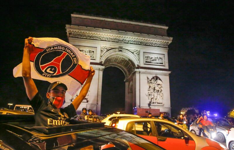 A supporter of the Paris Saint Germain soccer team celebrates on the Champs Elysee in Paris, AP