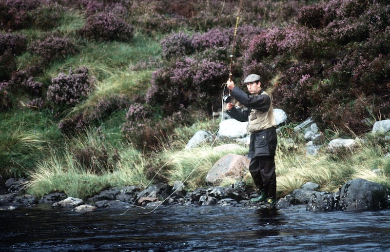 Britain's King Charles III, seen here fishing in the River Dee in 1982, is among those alarmed by the threat to the salmon population in Scotland. Getty Images