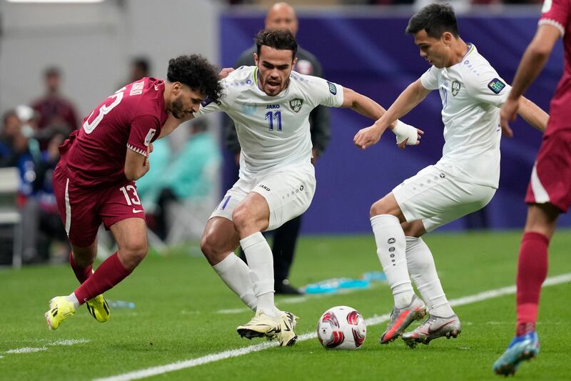 Qatar's Khalid Mazeed, left, fights for the ball with Uzbekistan's Oston Urunov. AP