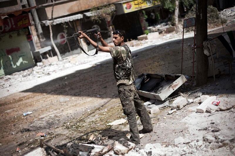 An FSA rebel fires his weapon against Syrian Army positions in Salaheddine district. Manu Brabo / AP Photo