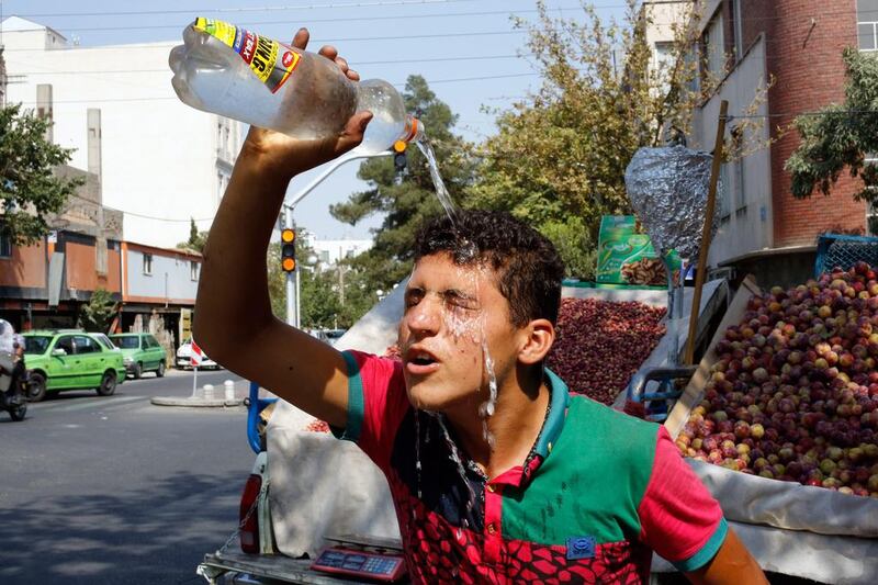An Iranian street vendor feels the heat. Abedein Taherkenareh / EPA