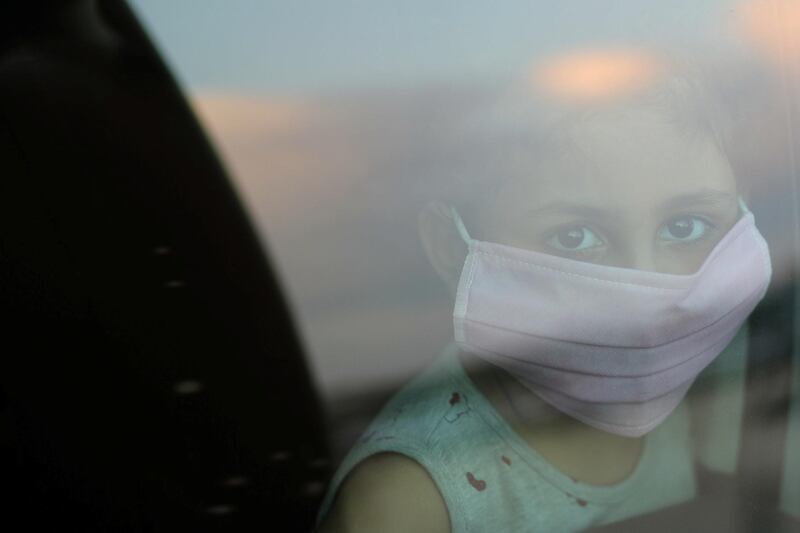 A boy wearing a protective face mask looks through a car window amid concerns about the spread of the coronavirus disease (COVID-19), in the southern Gaza Strip. REUTERS