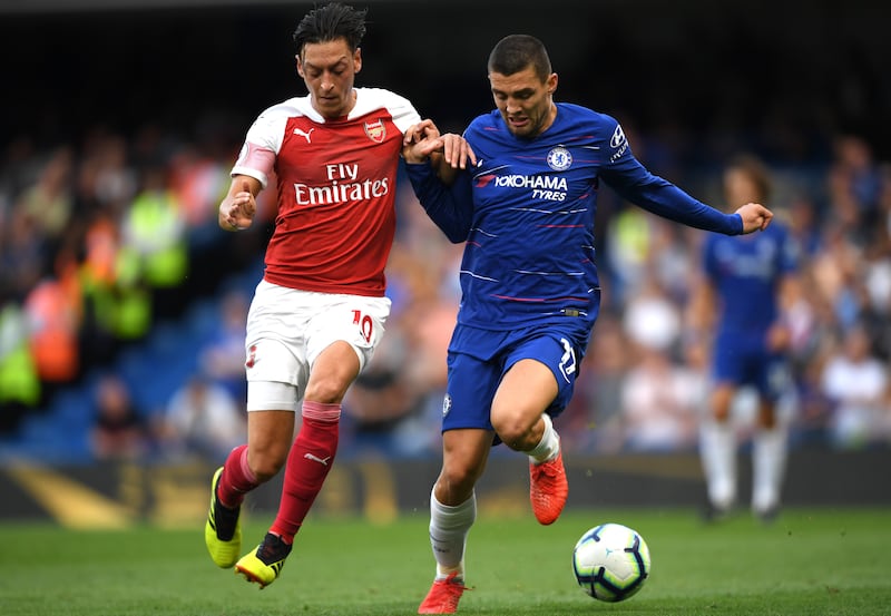 LONDON, ENGLAND - AUGUST 18:  Mesut Ozil of Arsenal battles for possession with Mateo Kovacic of Chelsea during the Premier League match between Chelsea FC and Arsenal FC at Stamford Bridge on August 18, 2018 in London, United Kingdom.  (Photo by Shaun Botterill/Getty Images)
