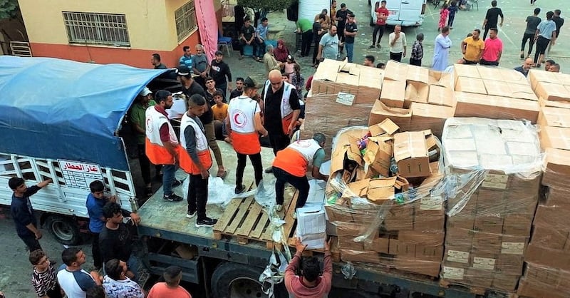 Members of the Palestine Red Crescent distribute aid to people in Deir Al Balah, in the central Gaza Strip. Palestine Red Crescent Society / Reuters