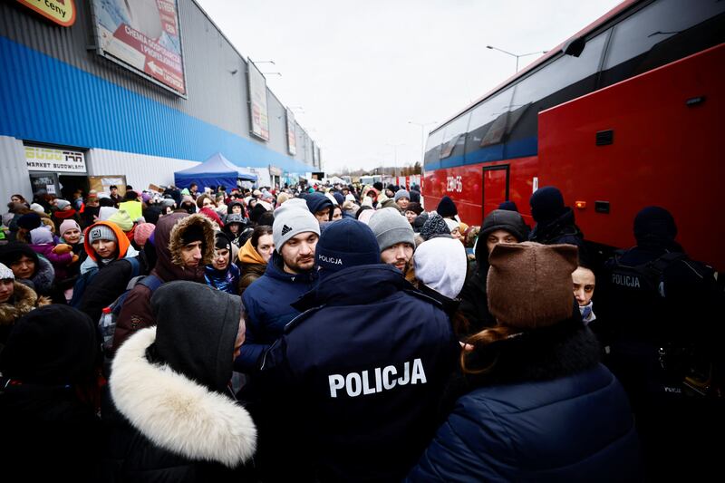 Police manage people as they wait to board a bus, at a temporary accommodation centre, after fleeing the Russian invasion of Ukraine, in Korczowa, Poland, March 6, 2022.  REUTERS / Yara Nardi