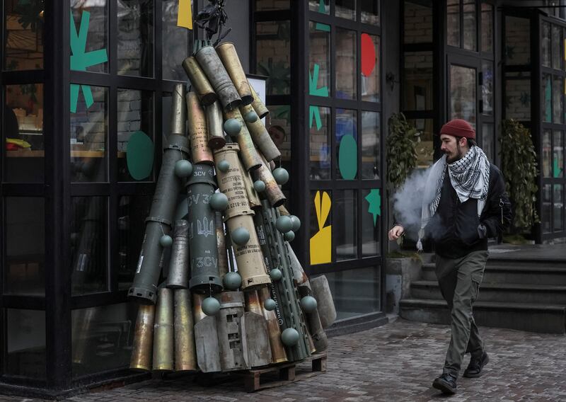A man passes by a symbolic Christmas tree made from used artillery shells transported to the Ukrainian capital from the front line, Kyiv, Ukraine. Reuters