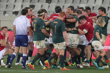 Referee Ben O'Keeffe, left looks on as tempers rise between British and Irish Lions' Maro Itoje, in skull cap and South Africa's Eben Etzebeth during the second rugby union test between South Africa's Springboks and the British and Irish Lions at the Cape Town Stadium, in Cape Town, South Africa, Saturday, July 31, 2021.  (AP Photo / Halden Krog)