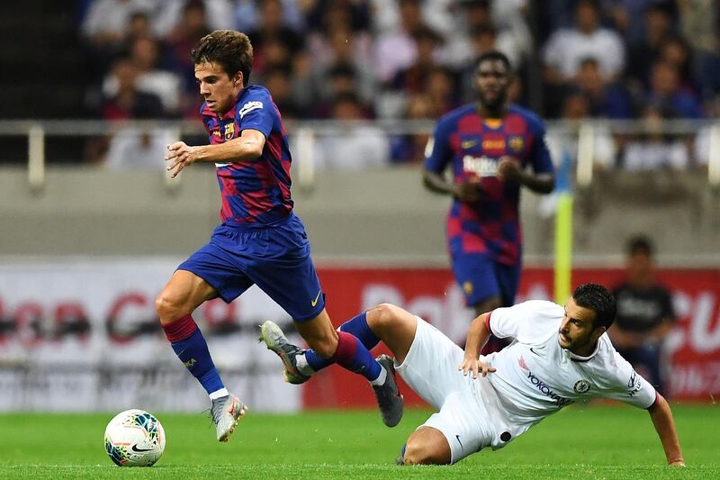 Barcelona midfielder Riqui Puig is challenged by Chelsea forward Pedro. AFP