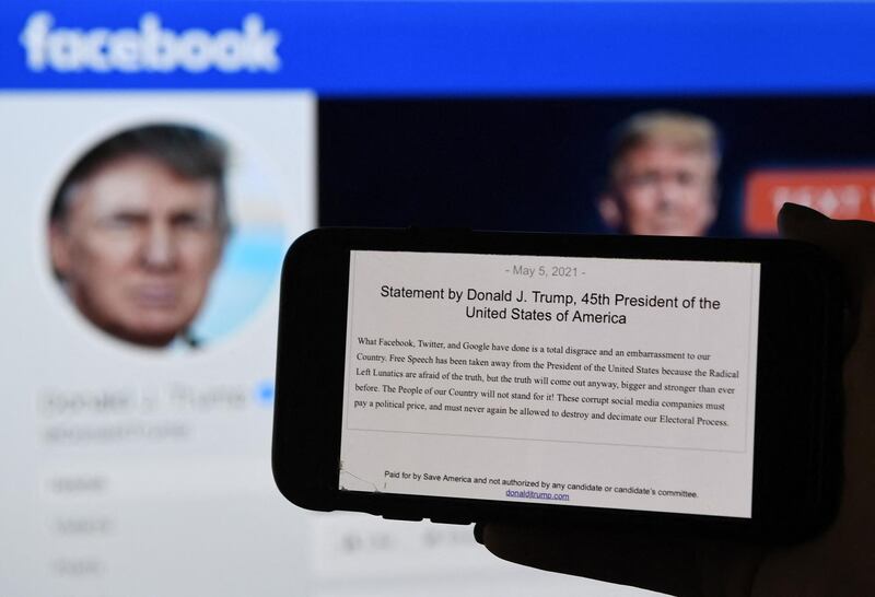 In this photo illustration, a phone screen displays the statement of former US President Donald Trump on his Facebook page background, on May 5, 2021, in Arlington, Virginia. Donald Trump said May 5, 2021 it was a "total disgrace" for online giants to institute social media bans, after a Facebook board upheld the company's restriction against the former US president which he argued infringed on his free speech."What Facebook, Twitter, and Google have done is a total disgrace and an embarrassment to our country," Trump said in a statement.
 / AFP / Olivier DOULIERY
