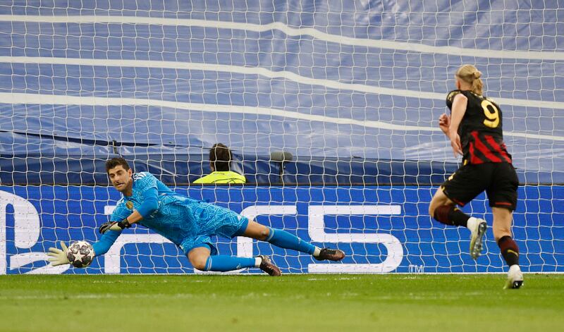 Real Madrid keeper Thibaut Courtois makes a save as Manchester City's Erling Haaland closes him down. Reuters