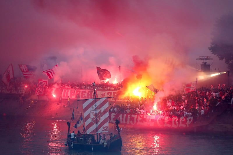 Red Star supporters light flares on the bank of the Sava river. AFP