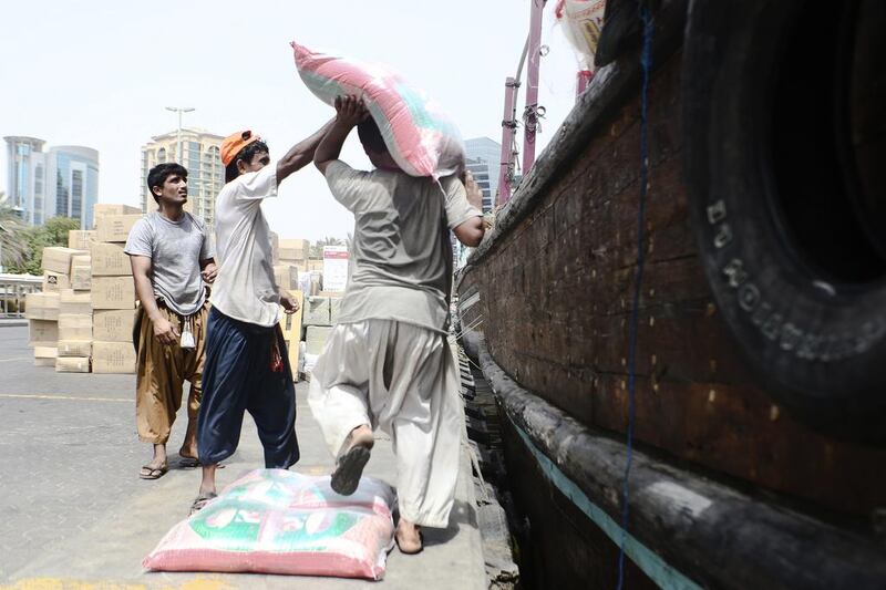 A group of sailors in Dubai loading bags of rice onto their boat. Lee Hoagland/The National