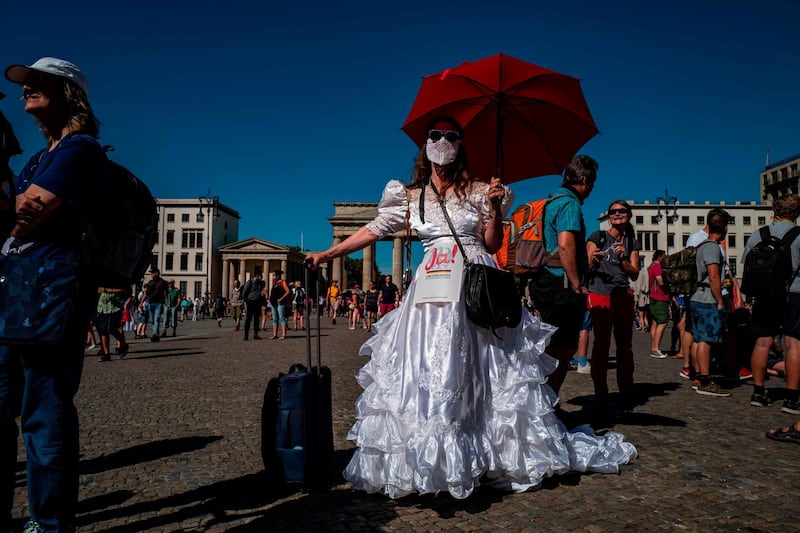A demonstrator in a wedding gown poses in front of the Brandenburg Gate with a sign reading: Yes to the (Germany's) basic law as she takes part in a demonstration by the initiative Querdenken-711 with the slogan 'The end of the pandemic - the day of freedom' to protest against the current measures to curb the spread of the Coronavirus in Berlin.  AFP