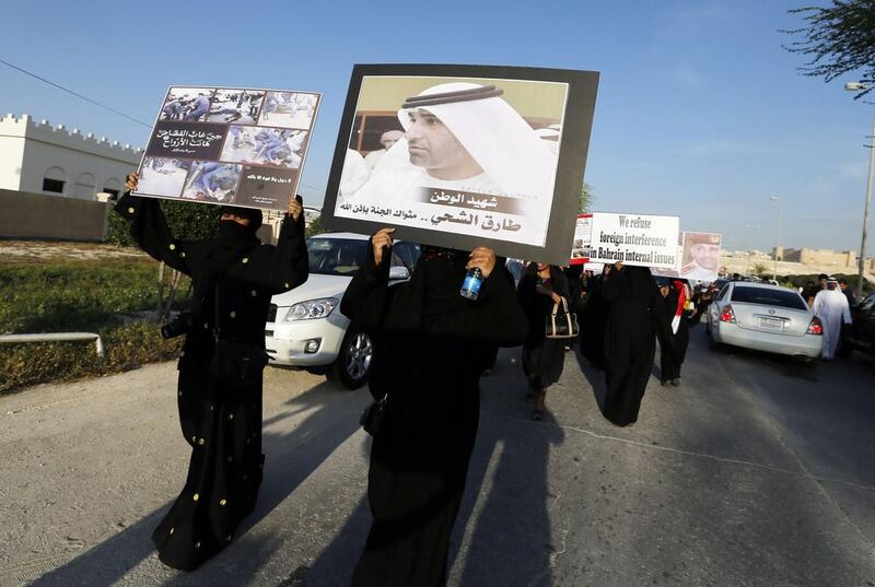Mourners, including family members of policeman Ammar Abdulrahman Ali, hold posters with pictures of UAE police officer First Lt Tariq Al Shehi, during a protest asking the government to implement tougher laws after Ali's funeral procession in Hananya, west of Manama, on March 4. Hamad I Mohammed/Reuters