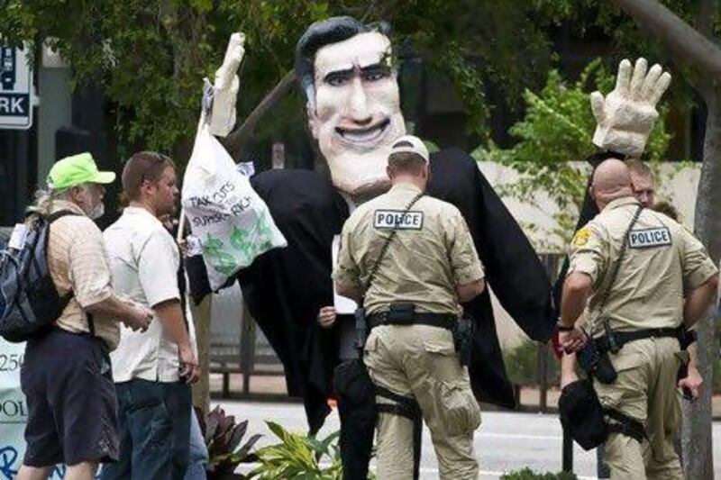 Police officers check the documents of protesters carrying an effigy of US Republican Party presidential candidate Mitt Romney during a demonstration outside a Republican national convention in Tampa, Florida.