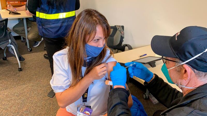 Grace John, who works at a school in San Lorenzo, gets a COVID-19 shot at a mobile vaccination clinic run by the Federal Emergency Management Agency and the state in Hayward, California. AP Photo
