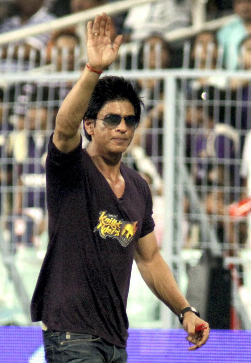 RESTRICTED TO EDITORIAL USE. MOBILE USE WITHIN NEWS PACKAGE
Indian Bollywood actor and co-owner of Indian Premier League (IPL) cricket team 'Kolkata Knight Riders' (KKR) Shah Rukh Khan (C) gestures to spectators during the IPL Twenty20 cricket match between Kolkata Knight Riders and Mumbai Indians at The Eden Garden Stadium on May 22, 2011. AFP PHOTO/STR (Photo by STRDEL / AFP)