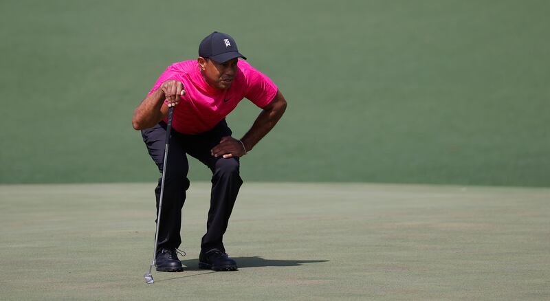 Tiger Woods lines up his putt on the second hole. EPA