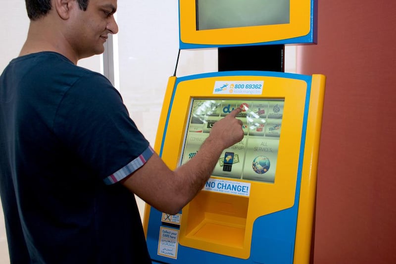 Employees at the FMW/ManGo offices in Dubai Media City demonstrate the new payment kiosk machine which also accepts Bitcoin. This is the first Bitcoin enabled machine in the UAE. Photo by Clint McLean for The National