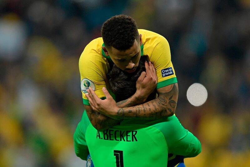Brazil's Gabriel Jesus celebrates with goalkeeper Alisson after scoring his penalty to defeat Paraguay. AFP