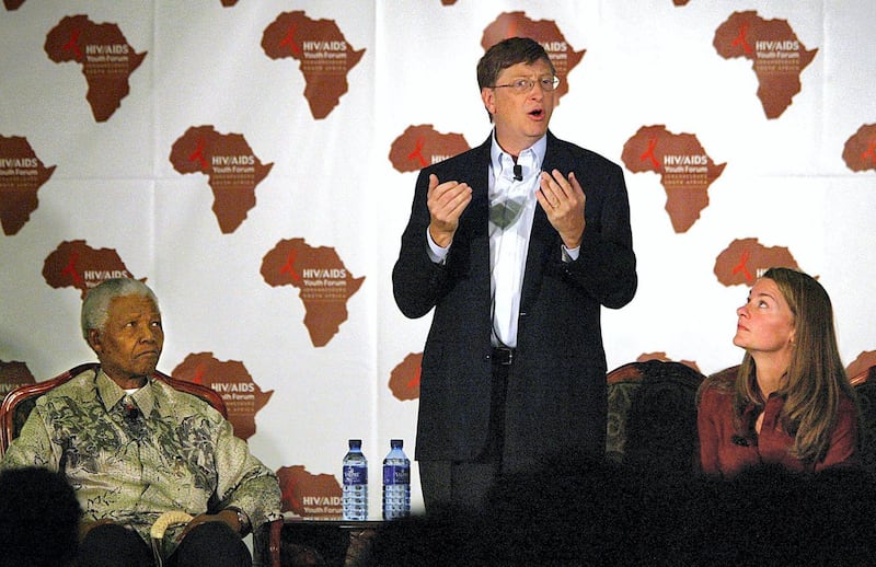 US Microsoft owner Bill Gates (C) addresses a youth forum on HIV/AIDS at the University of Witwatersrand in Johannesburg, 22 September 2003, as his wife Melinda Gates and former South African President Nelson Mandela (L) listen to him. Mandela and Gates took part in the forum that was held to raise awareness of the AIDS epidemic in South Africa. The Bill and Melinda Gates Foundation has already awarded several billion dollars to fund global health projects.       AFP PHOTO / ALEXANDER JOE (Photo by ALEXANDER JOE / AFP)