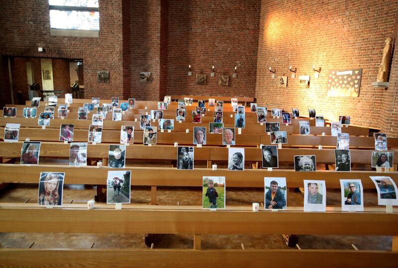 Photos of believers who were asked to send in pictures instead of attending are attached to the pews for a livestreamed service in the empty St. Barbara church in Obrhausen, Germany.  EPA