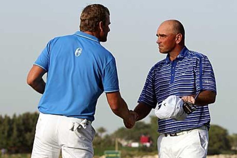 Robert Karlsson, left, shakes hands with Thomas Bjorn at the end of the third round's play.