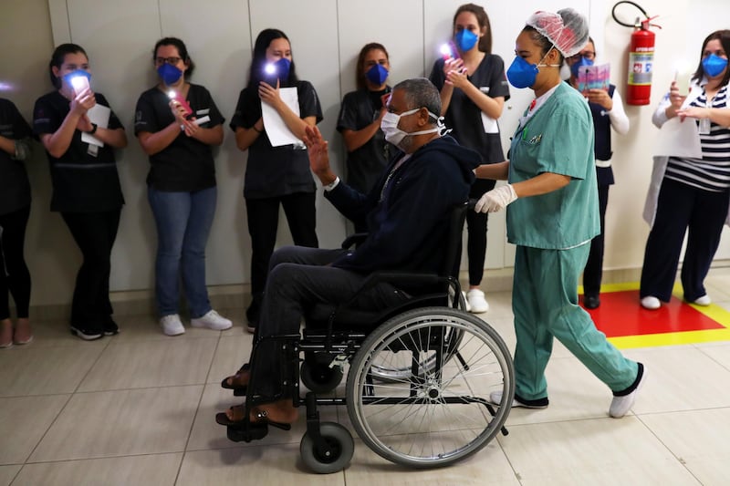 Health workers light their phones in his honour as Jose Queiroz dos Santos, 62, is discharged after surviving coronavirus disease at Parelheiros Municipal Hospital in Sao Paulo, Brazil. Reuters